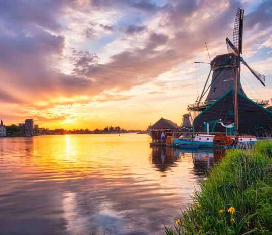 Windmills At Zaanse Schans In Holland On Sunset.