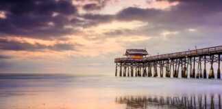 Cocoa Beach Pier at sunset reflected in the water