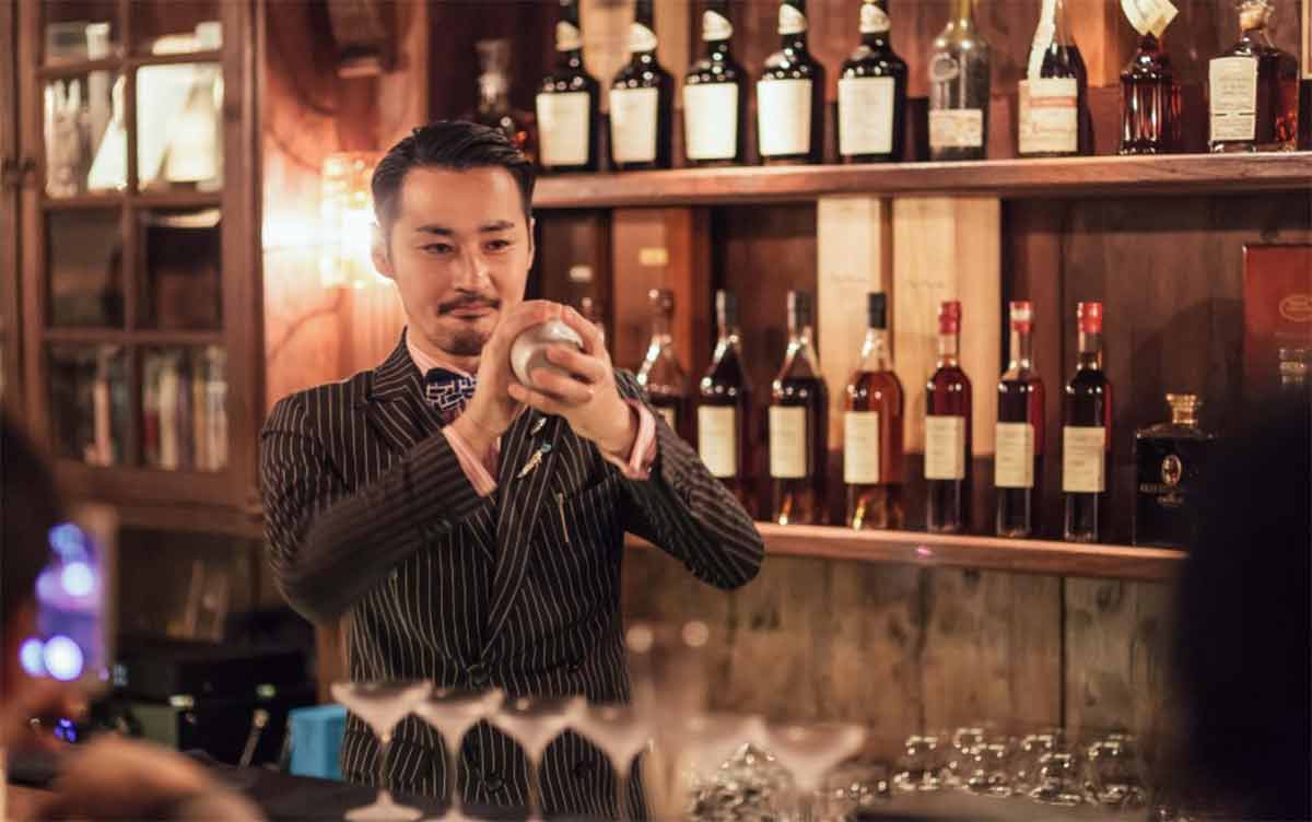 Bars in Singapore D.bespoke smartly dressed bartender in pin-striped suit shaking a cocktail