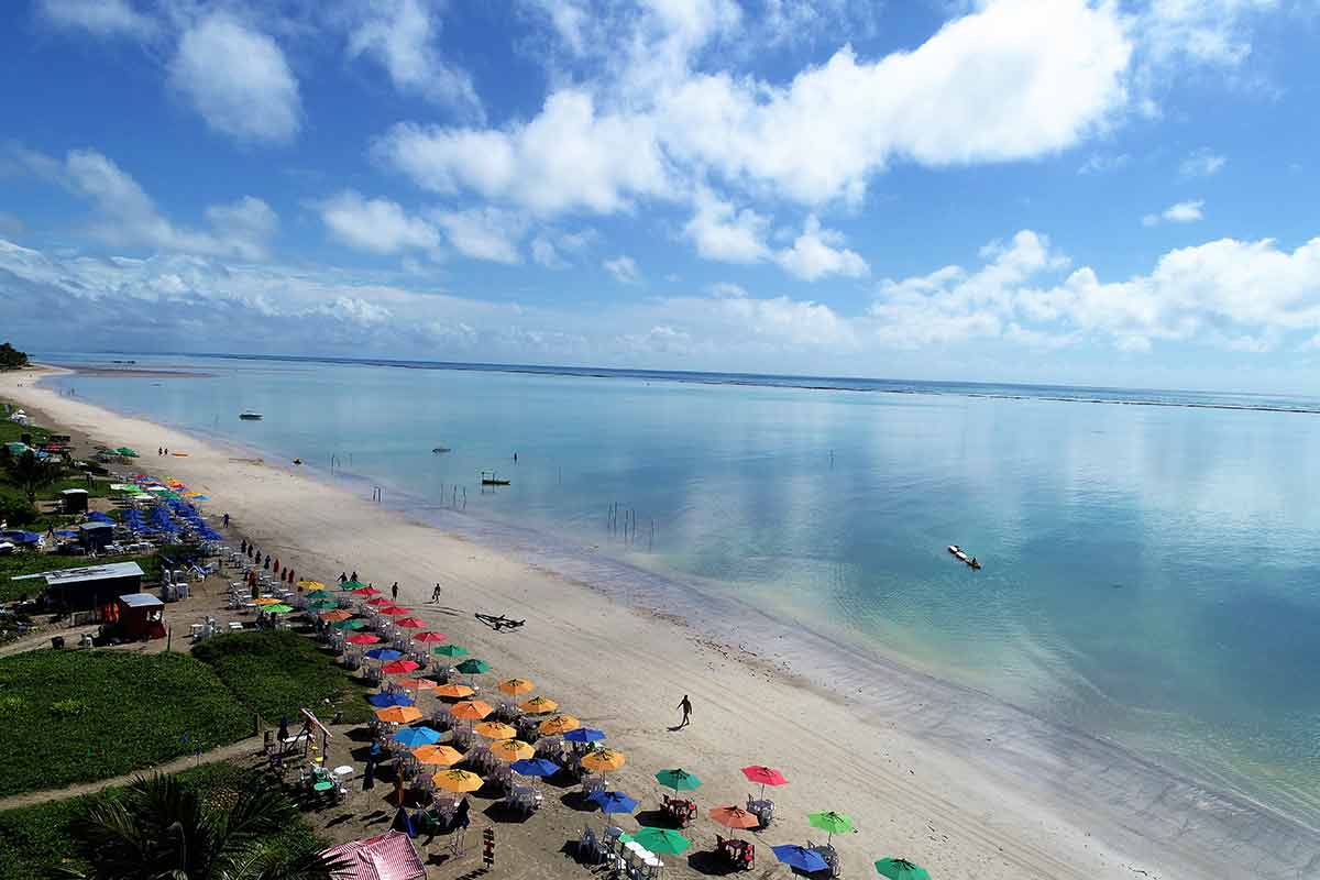 Beaches Brazil aerial view of rows of colourful beach umbrellas at Maragogi Beach