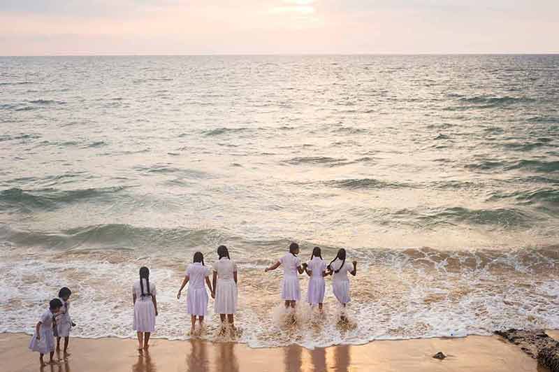 Beaches Sri Lanka Schoolgirls on the beach getting wet in their uniforms
