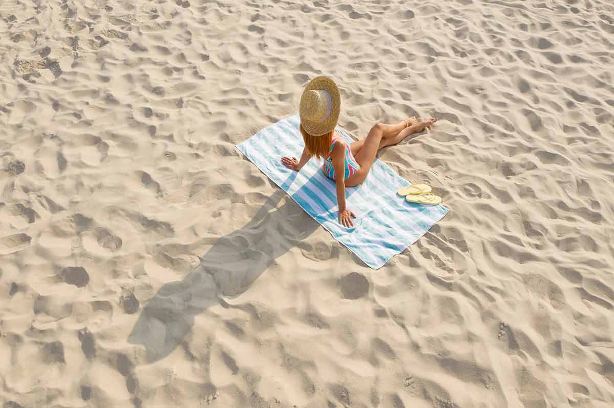 A model on a towel on one of the sandy beaches in England