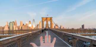 Boston to Miami New York City hand with upturned palm pointing towards New York City across the bridge