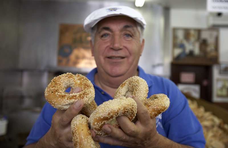 A baker in Montreal holding bagels, Canadian food
