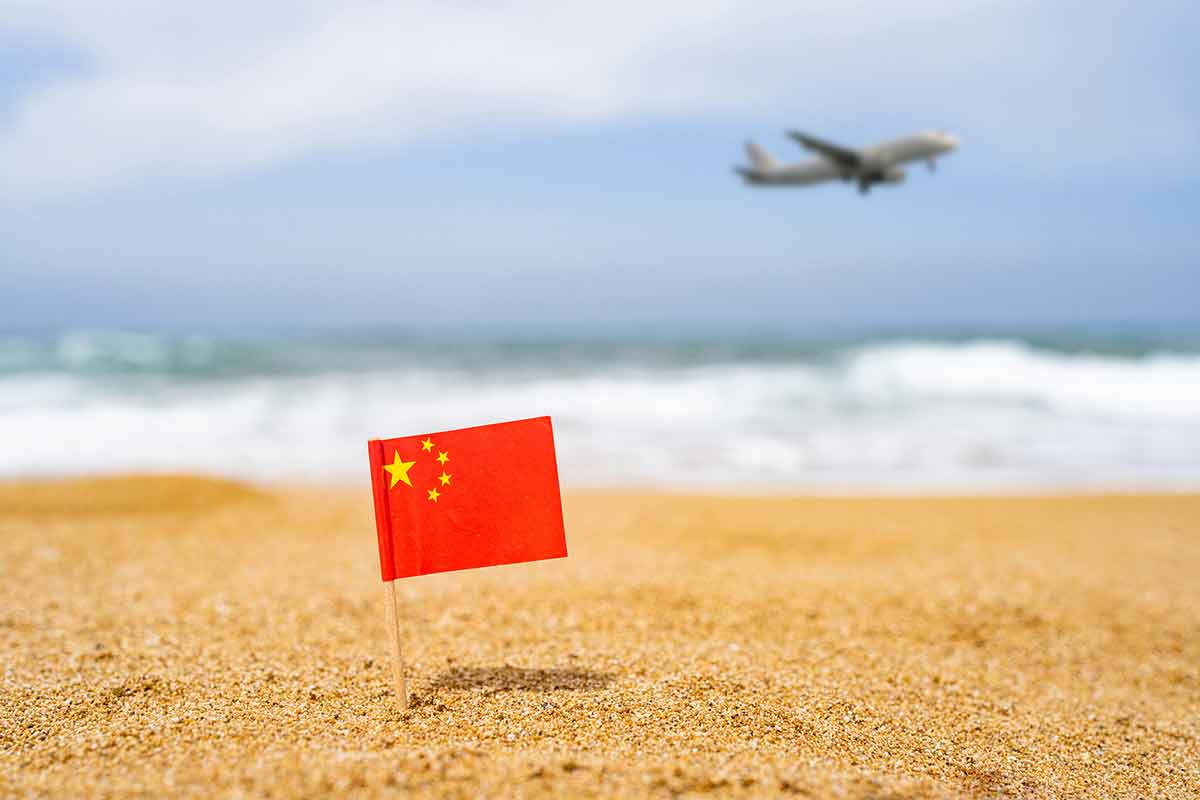 China Beaches chinese flag in the sand with a plane flying in the background