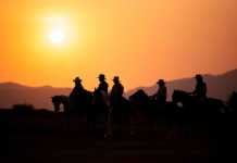 Christmas cowboy boots and riders at sunset