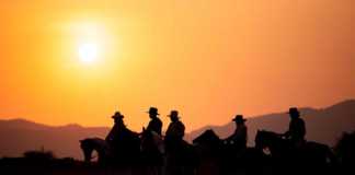 Christmas cowboy boots and riders at sunset