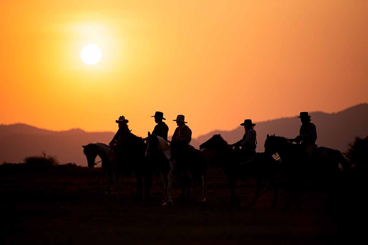Christmas cowboy boots and riders at sunset