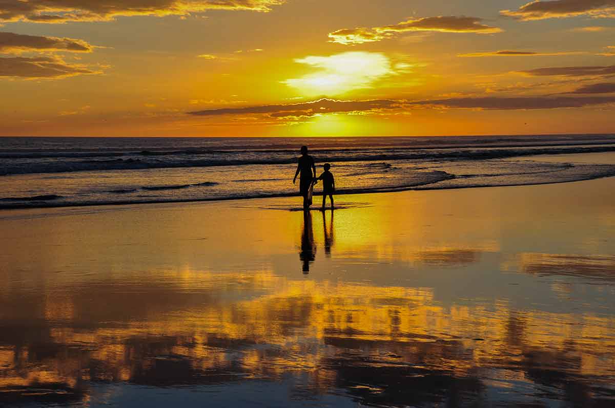 El Salvador beaches el cucho man and child in silhouette walking in the beach