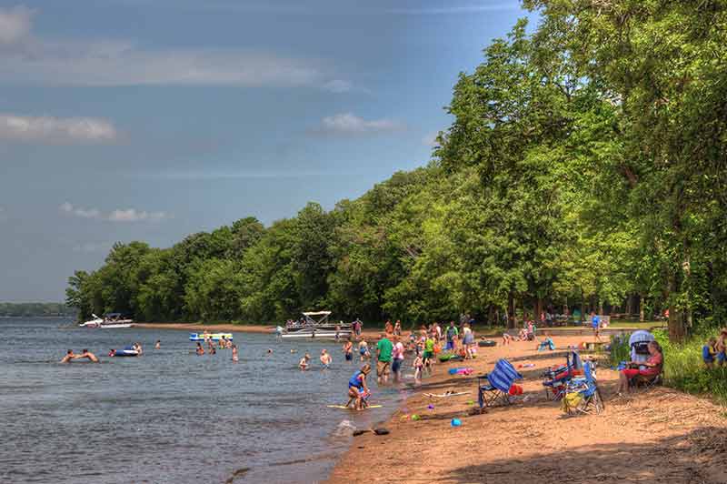 families enjoying the beach in summer at Father Hennepin State Park Minnesota