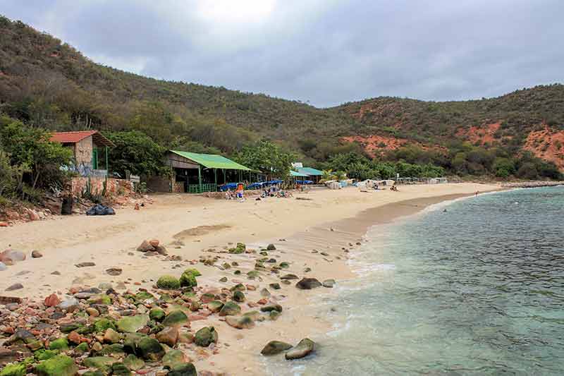 Mochima National Park beach Venezuela beach shacks and people lying on the sand