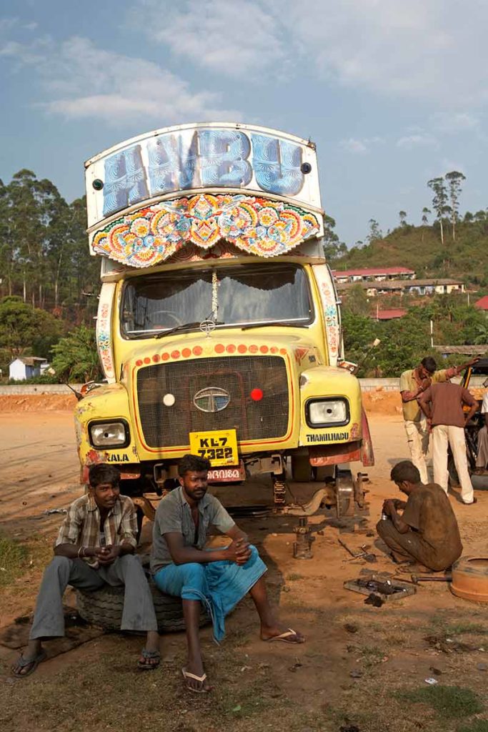 workers resting in front of a painted lorry in Kerala