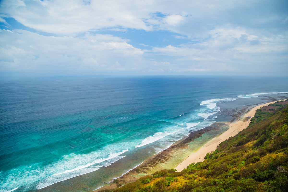 Nunggalan Beach Bali aerial with waves lapping at the sand