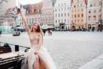 Polish drinks A bride in a wedding dress with long hair and a drink bottle in the Old town of Wroclaw.