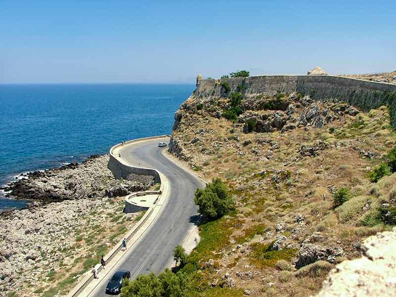 the road leading to Rethymno Fortress with blue ocean in the background