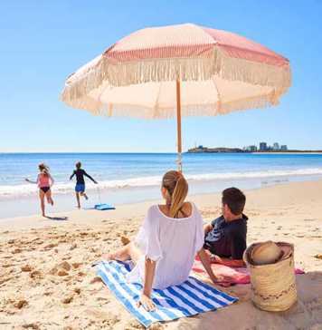 Couple under an umbrella on a Sunshine Coast beach