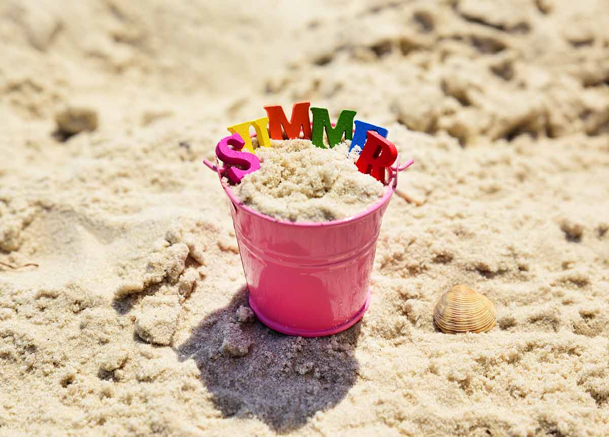Tennessee Beaches pink bucket filled with sand and the letters spelling out the world summer
