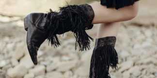 Texas beaches legs standing on a beach in a pair of fancy black cowboy boots