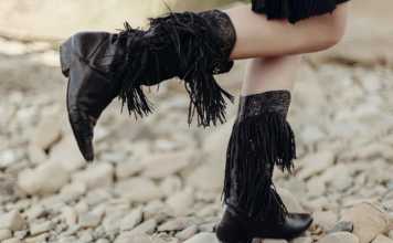 Texas beaches legs standing on a beach in a pair of fancy black cowboy boots