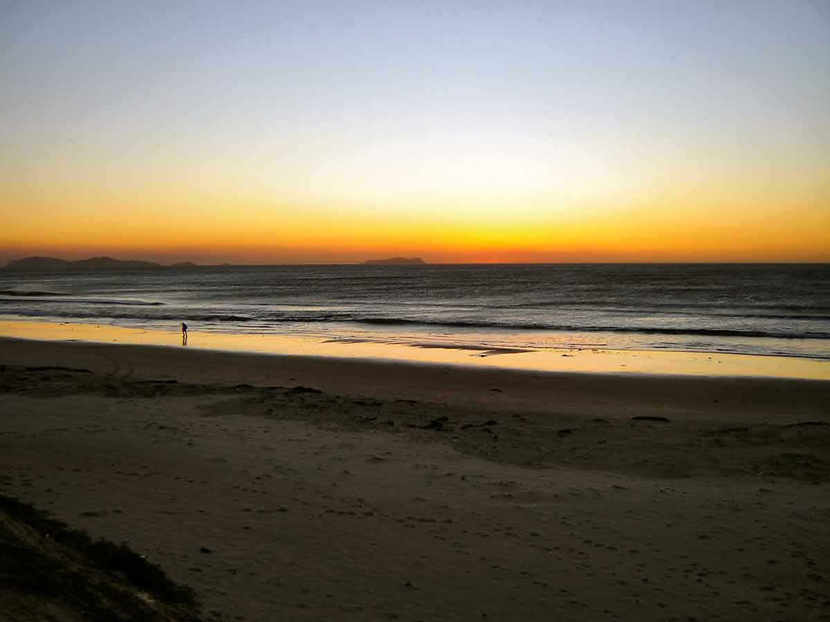Tijuana beach sunset lone person walking on the sand