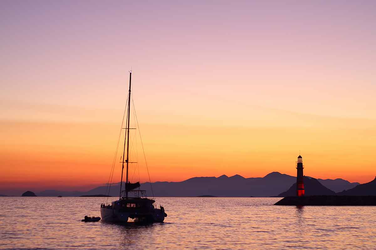 Turgutreis resorts in turkey yacht and lighthouse at sunset