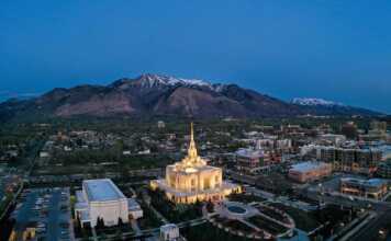 aerial view of Ogden at night with the Mormon temple lit up and snowcapped mountains in the background