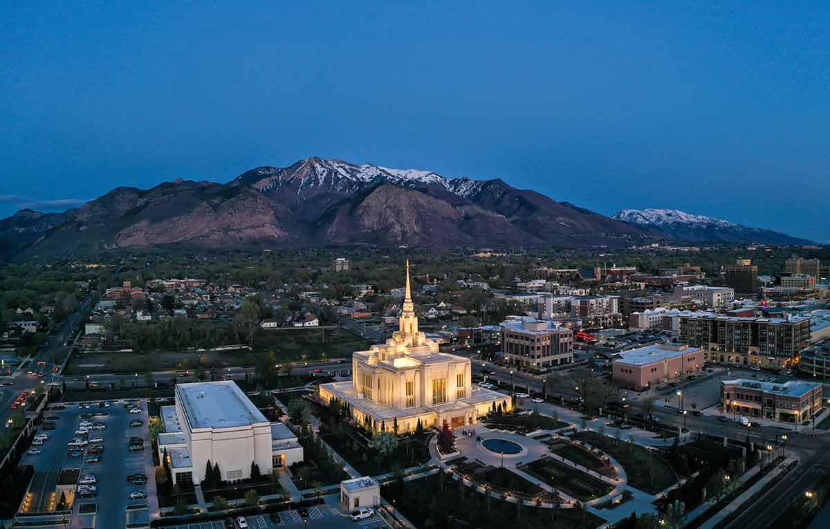 aerial view of Ogden at night with the Mormon temple lit up and snowcapped mountains in the background