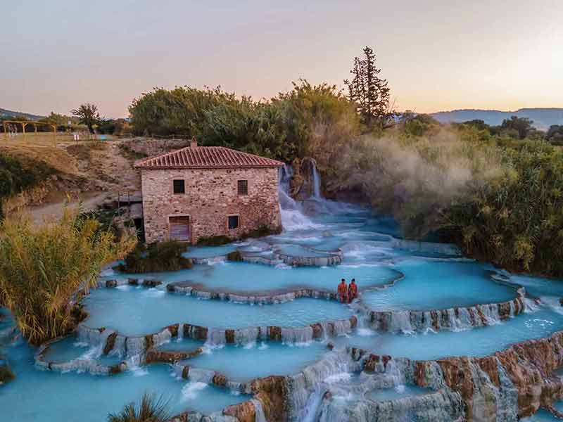 Winter Italy a couple in Saturnia Cascate del Mulino hot springs