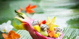 asian fruit salad served in dragon fruit skin on a banan leaf