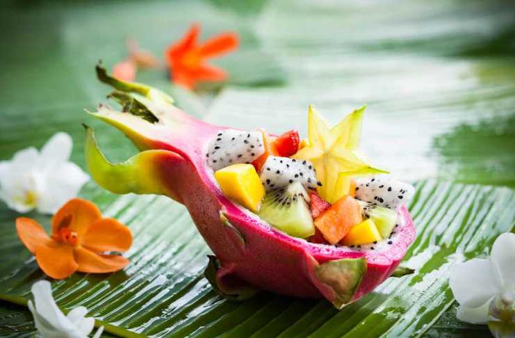 Asian Fruit That Looks Wild but Tastes Incredible asian fruit salad served in dragon fruit skin on a banan leaf