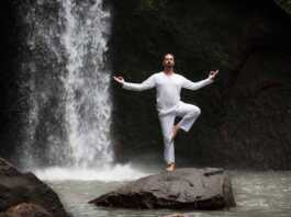 Man Standing In Meditation, Yoga On Rock At Waterfall