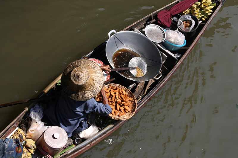 bangkok floating markets full of food and a wok