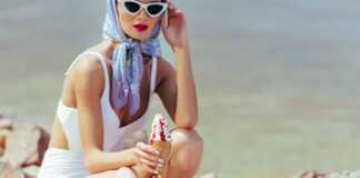 Woman in white swimsuit holding an ice cream on the beach