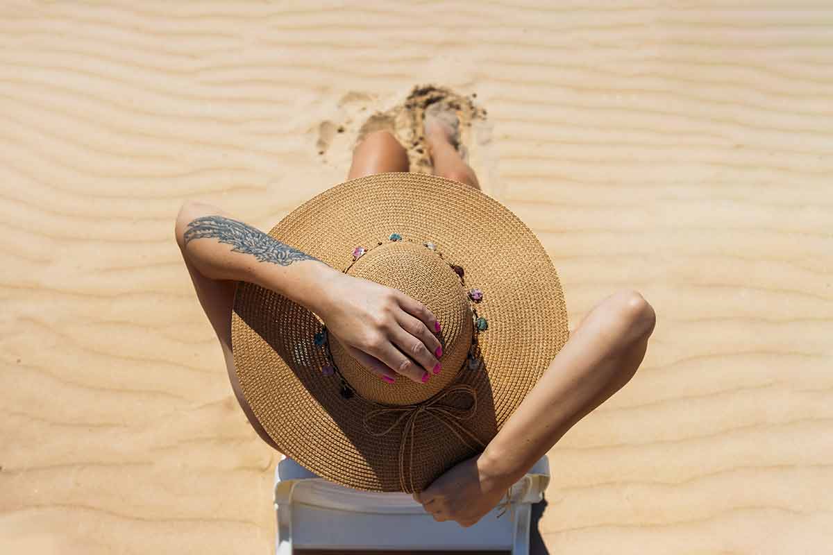 Top view of woman wearing straw hat on beach