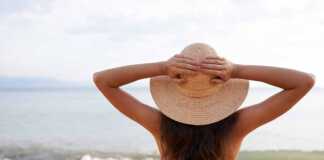 woman in straw hat looking at the ocean