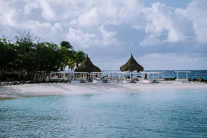 beaches curacao thatched umbrellas and day beds
