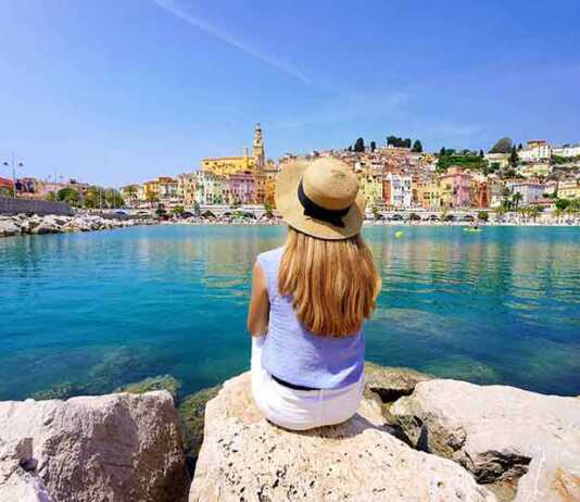 beaches french riviera Girl sitting on stone enjoying landscape of French Riviera on sunny day,