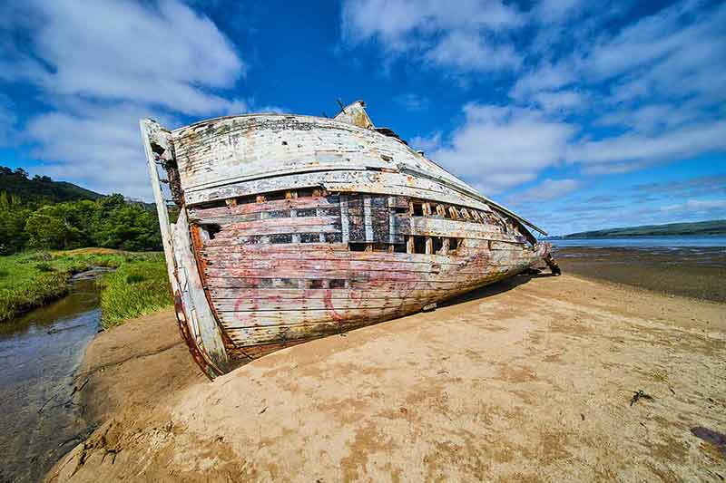 beaches grenada Image of Side hull of red and white shipwreck on sandy beaches with blue sky