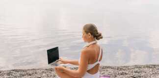 woman with notebook doing some work by a lakeside beach