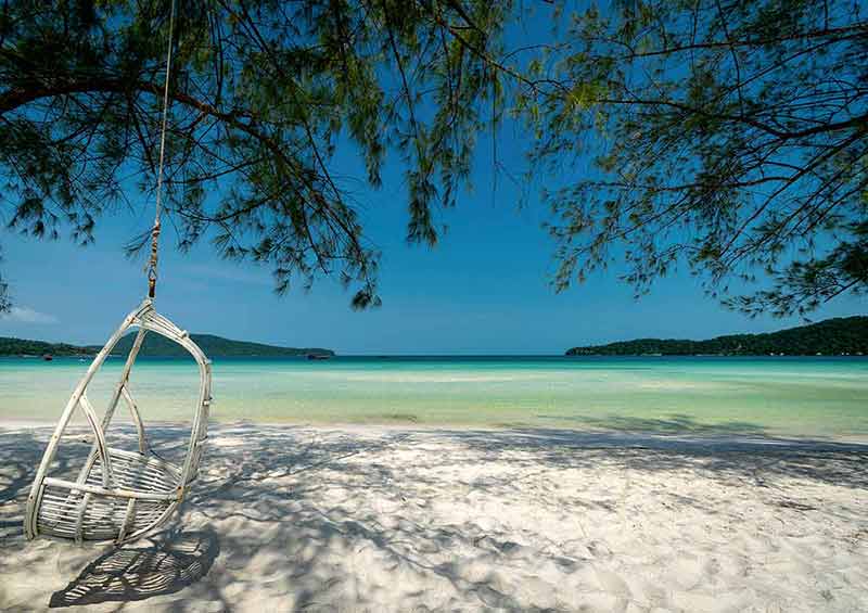 beaches in cambodia white swing hanging from a tree over white sand