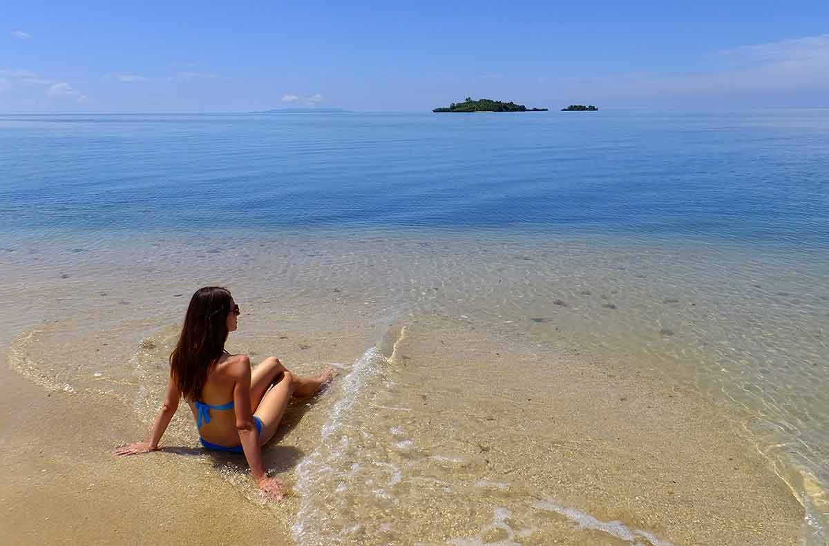 beaches in fiji young woman in blue bikini sitting on a beach in Vanua Levu