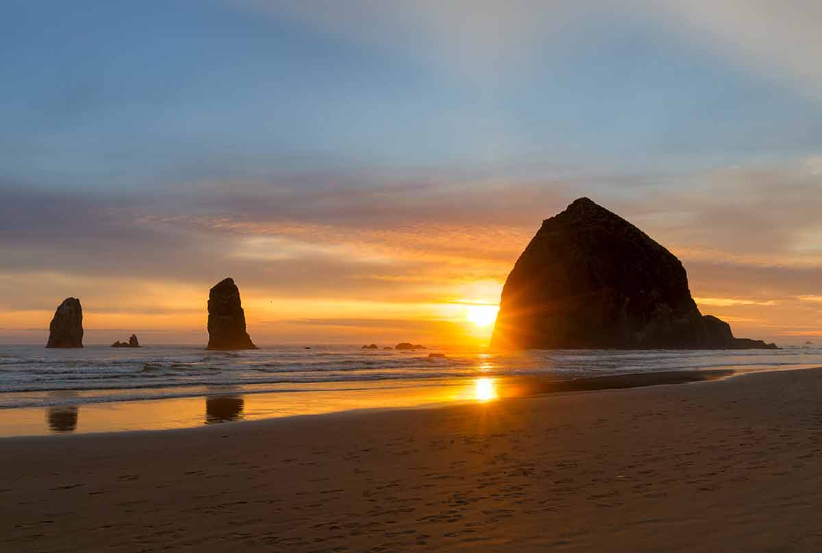 beaches in oregon coast sunset over Haystack Rock and the Needles at Cannon Beach