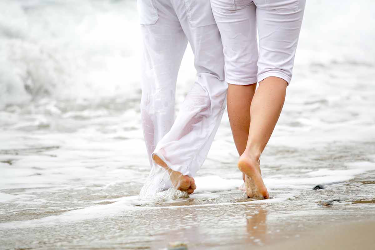 beaches in virginia couple in white pants walking on the beach