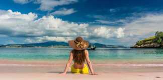 woman in yellow bikini sitting on a tropical beach