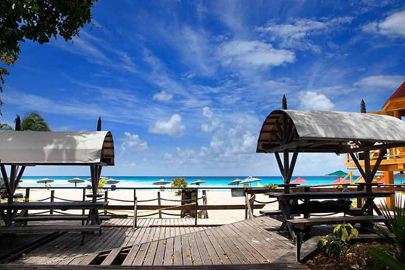 beaches resort barbados boardwalk at Dover Beach with umbrellas by the water