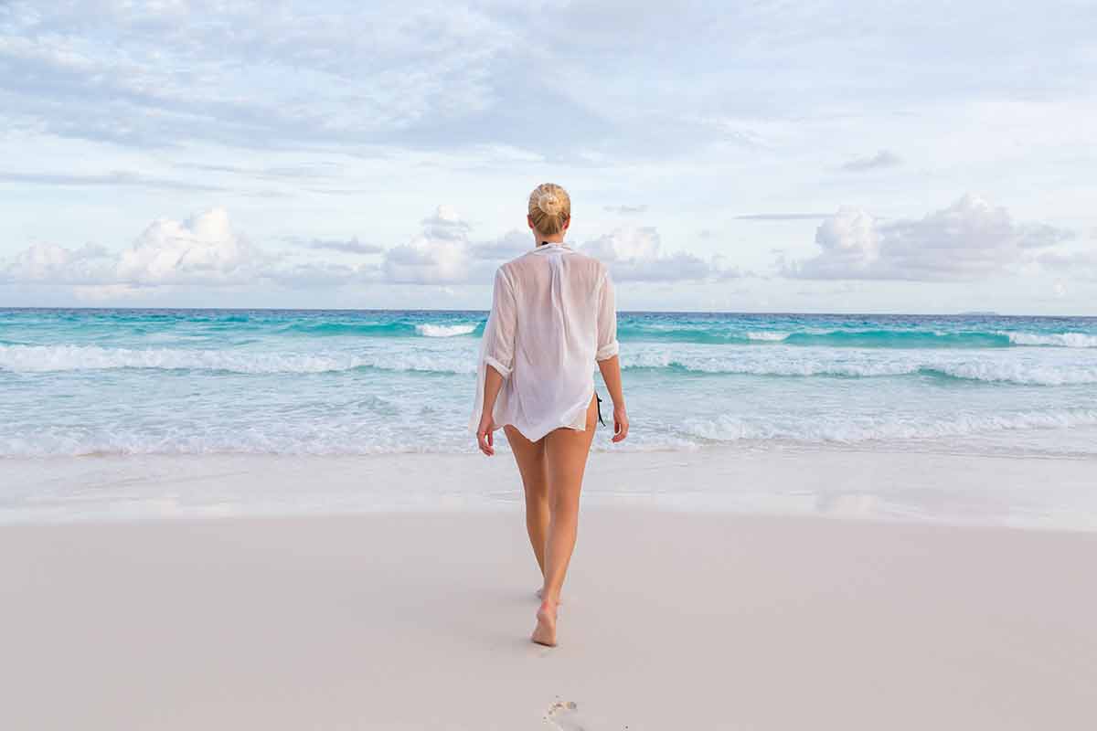 beaches seychelles woman in white see-through beach shirt