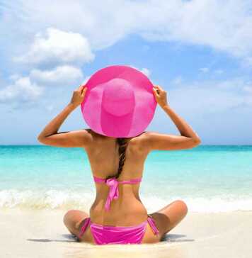 woman in pink hat and matching bikini on beach