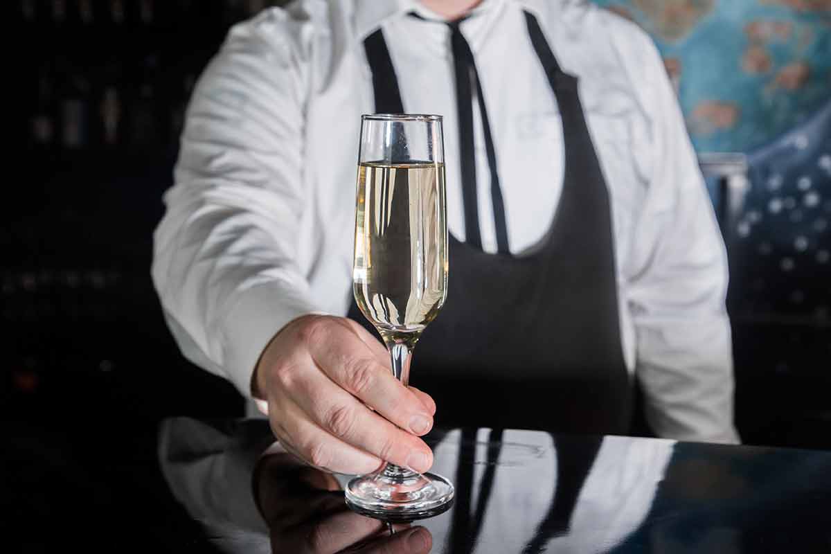 best bars west hollywood A professional bartender serves chilled champagne sparkling with gases in glass on the bar.
