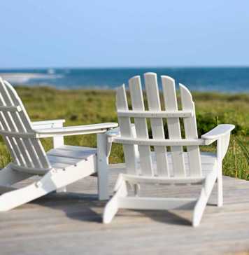 best beaches in north carolina for families Adirondack chairs on a deck looking towards the beach on Bald Head Island