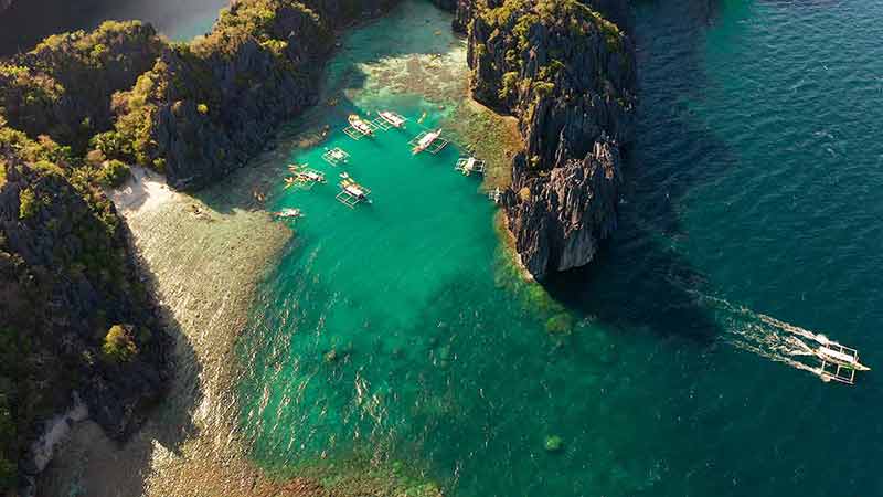 best beaches in philippines Tourist boats over tropical lagoon and coral reef, aerial view.